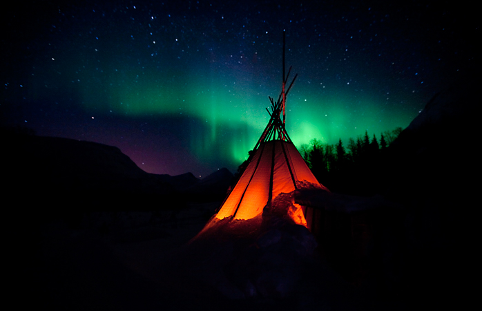 Uma típica tenda lavvo norueguesa sob a Aurora Boreal na Noruega