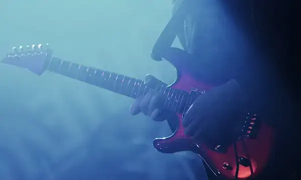Music background with guitarist on blue background