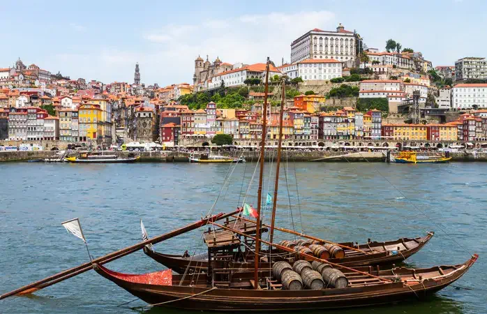 Landscape of the old city of Porto (Portugal). The Clerigos Tower (Torre dos Clerigos) can be seen on the middle of the picture and the Igreja da Misericordia on the left. The Catedral de Porto is on the right. There are boats in the river Duoro, they were used to bring wine. It's a sunny day of summer.