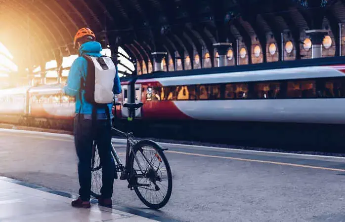 Young man who wearing helmet, is with bicycle on a public transport.